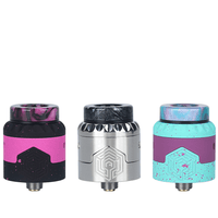 Three Advken Artha Gen 2 RDAs in black, silver, and turquoise with unique designs.