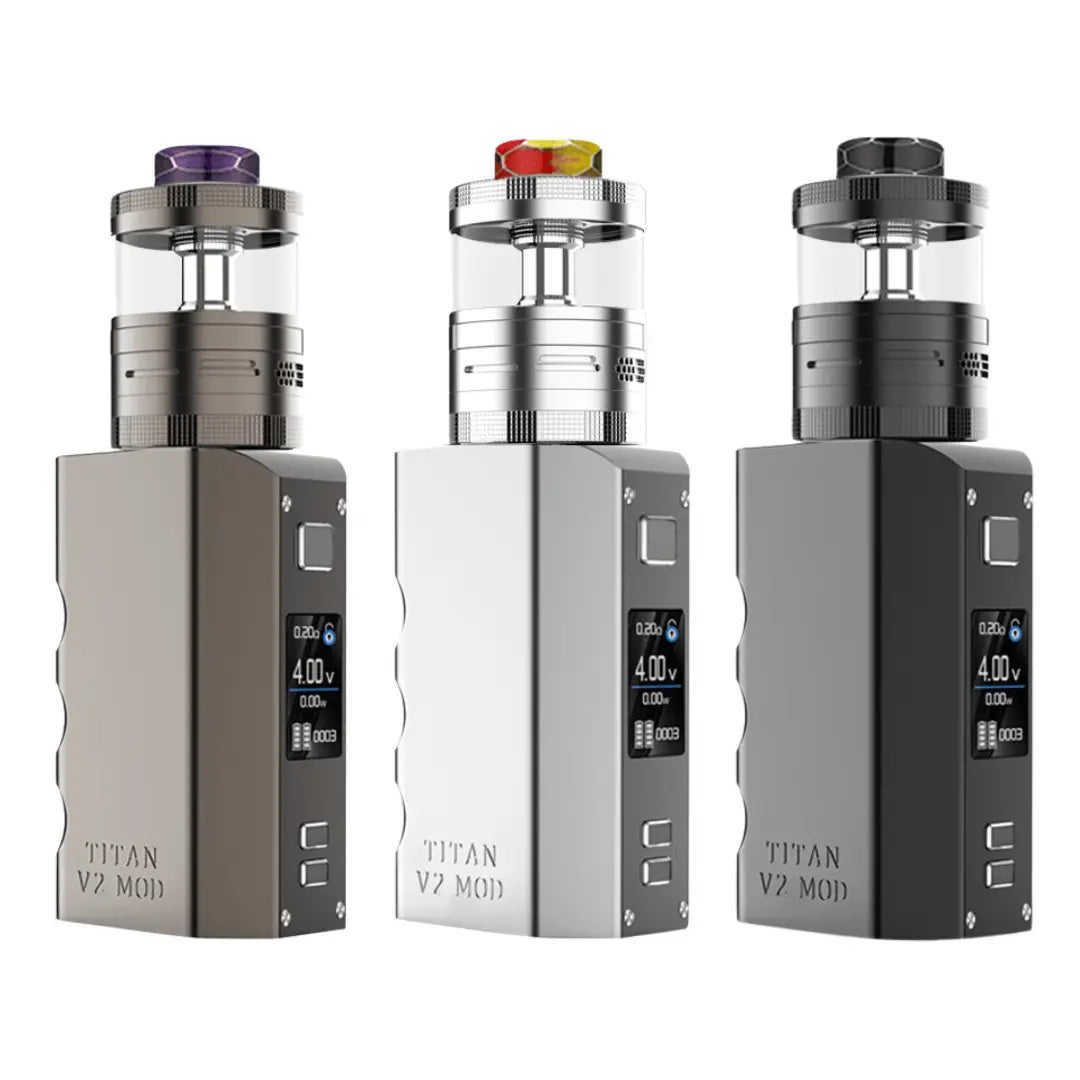 Three Steam Crave Titan V2 Combo Vape Kits displayed side by side. Each kit consists of a robust box mod with a large digital display and a matching RDTA (Rebuildable Dripping Tank Atomizer) on top. The left vape kit is in gunmetal, the middle one is silver, and the right one is in black. Each atomizer has a colourful resin drip tip, with the colours being purple, red/yellow, and black. The "Titan V2 Mod" branding is engraved on the side of each mod.