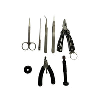 individual vape coil building tools displayed against a white background, including scissors, tweezers, pliers, wire cutters, and a precision screwdriver, along with a small round coil jig.